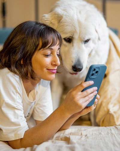 Woman exploring veterinary services on phone with dog